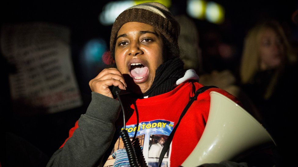 Erica Garner with a megaphone, leading demonstration after decision not to indict officers in her father's death