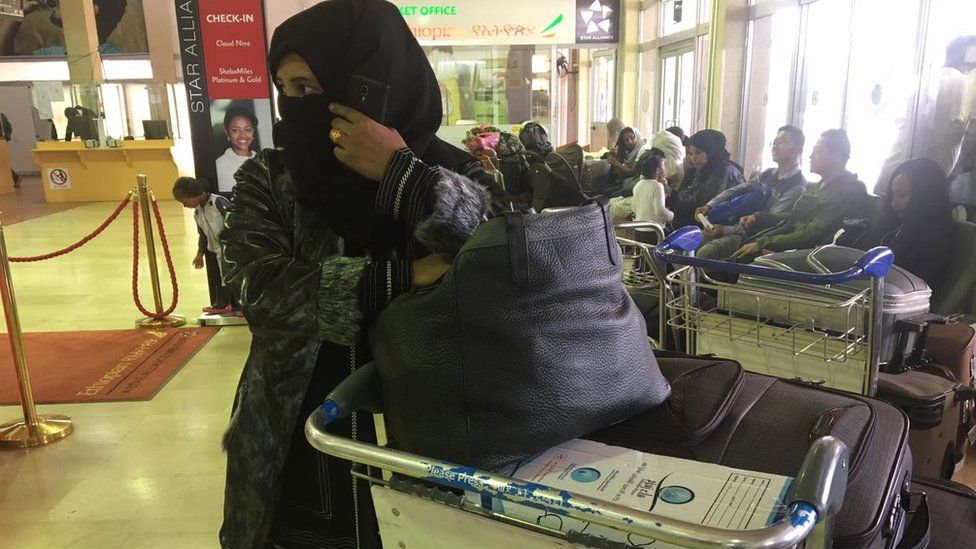Woman covering her face in an airport