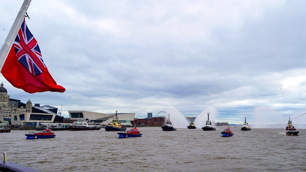 River tugs perform Fleur De Lis, (spraying of water from their fire cannons) as vessels gather on the River Mersey in Liverpool