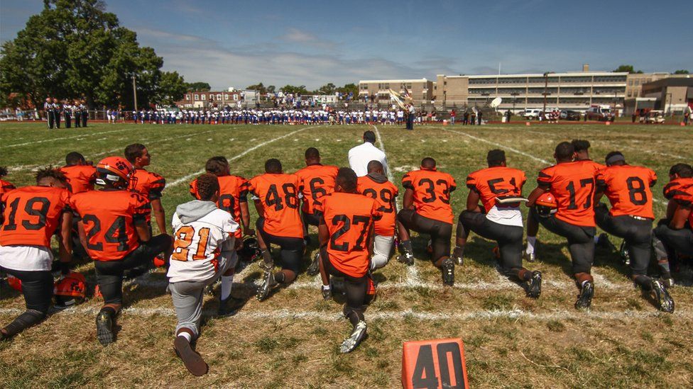 The Tigers kneel at the start of Saturday's game