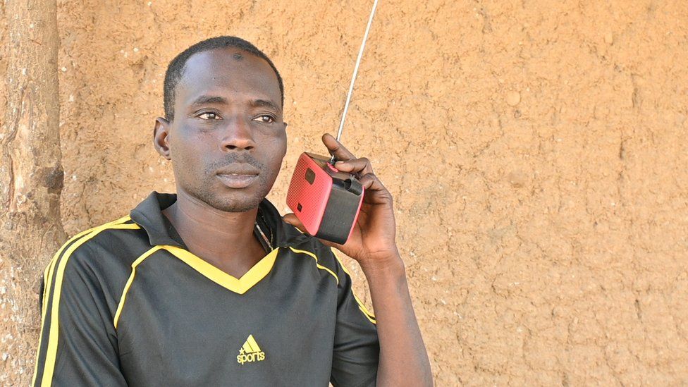 A man holding a radio to his ear