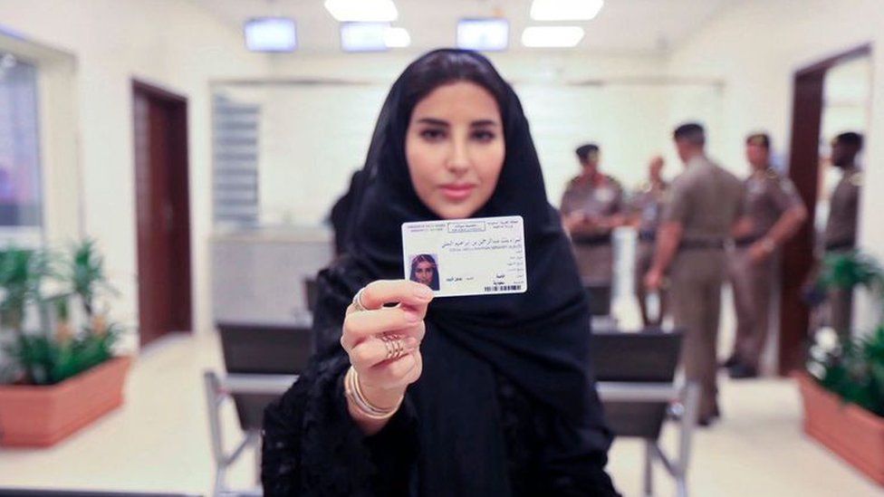 A woman shows her Saudi driving license