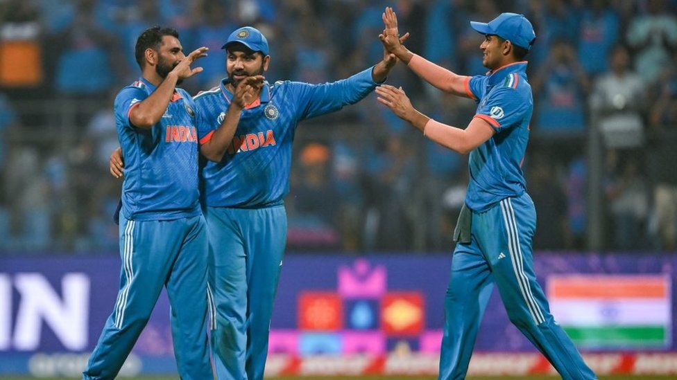 India's captain Rohit Sharma celebrates with teammates Mohammed Shami (L) and Shubman Gill (R) after winning the 2023 ICC Men's Cricket World Cup one-day international (ODI) first semi-final match between India and New Zealand at the Wankhede Stadium in Mumbai on November 15, 2023.