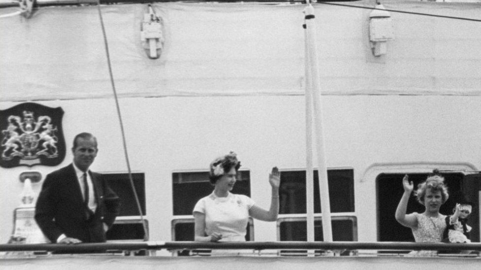 The Queen, Duke of Edinburgh and Princess Anne, still holding her Welsh Doll, on the Royal Yacht as it sails from Cardiff Bay