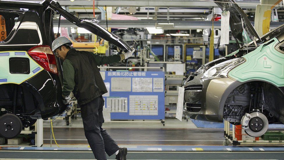 A man looks into the car on a Toyota production line in Japan