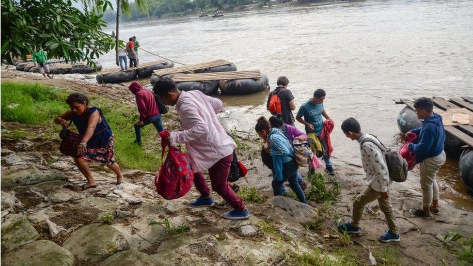 Migrants cross the Suchiate River, which delimits the border between Guatemala and Mexico, in the state of Chiapas, Mexico, on 11 June 2019. T