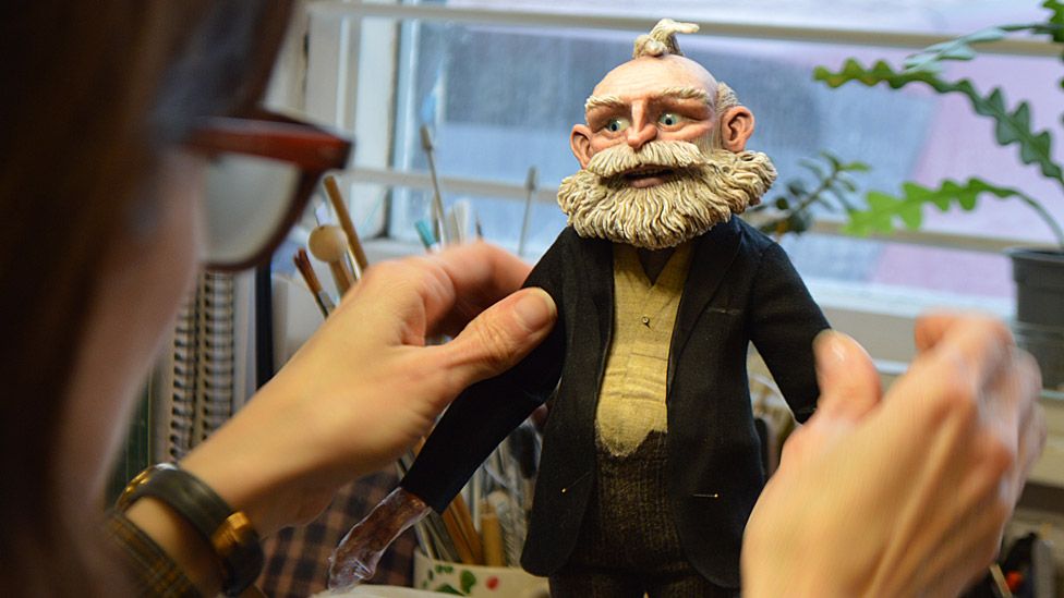 Geppetto model being fitted with a dinner jacket by a Mackinnon and Saunders costume maker