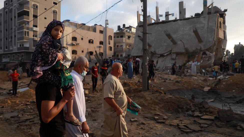 Palestinians assess the damage in Gaza after a night of air strikes by Israeli forces