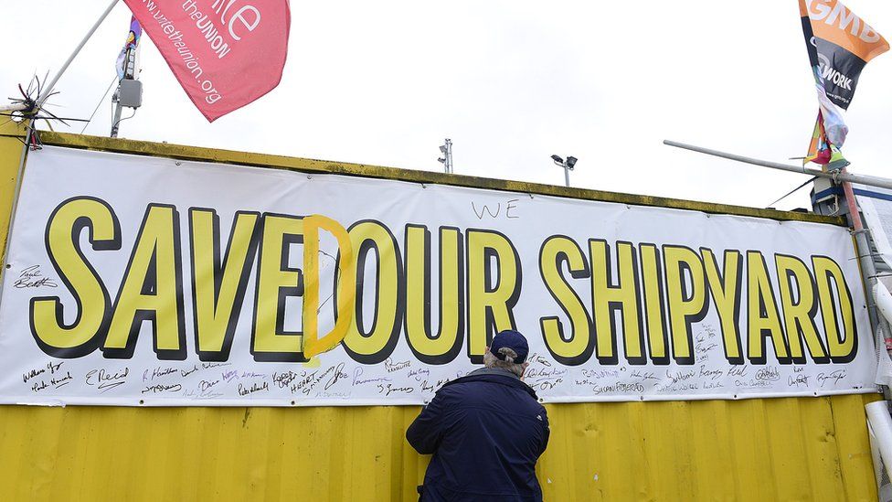 Man signing 'Saved our Shipyard' poster at Harland and Wolff