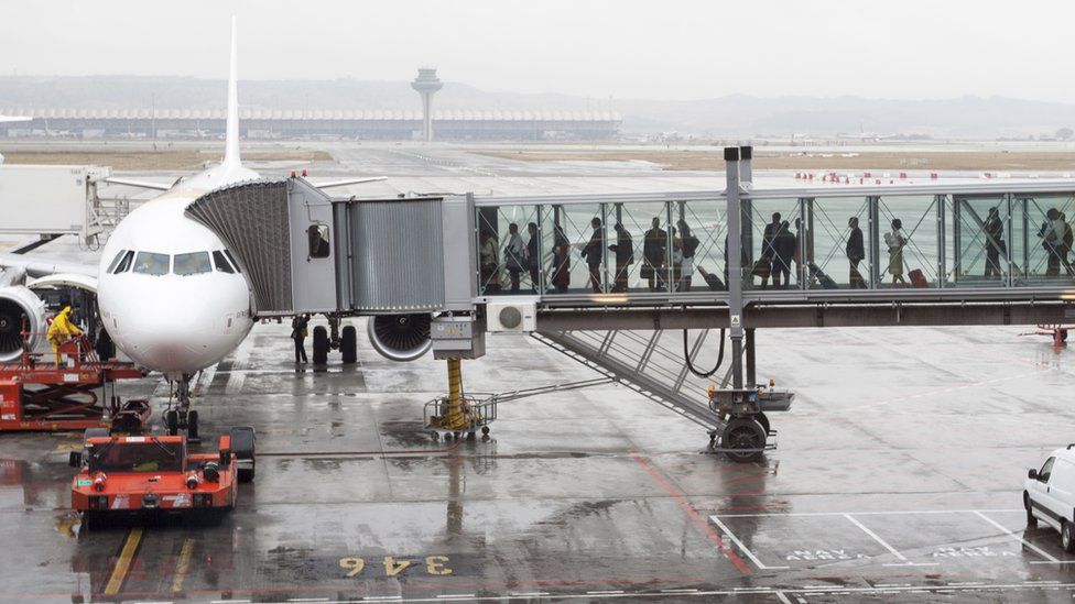 Пассажиры садятся в самолет в мадридском аэропорту Барахас