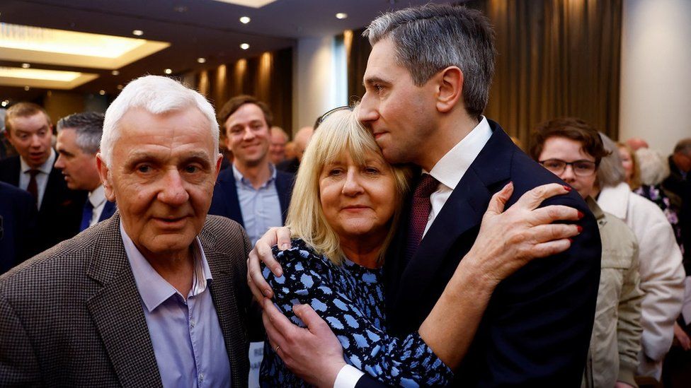 Simon Harris embracing his mother Mary with his father Bert