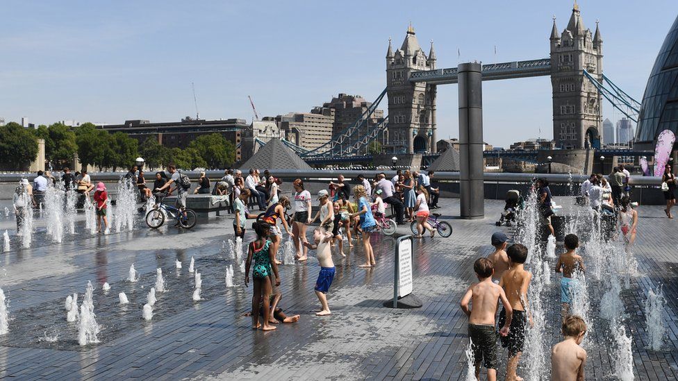 People playing in water fountains by Tower Bridge in London