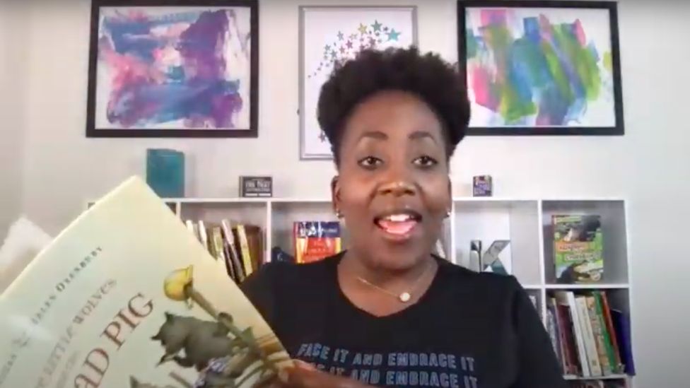 Keisha Yearby holds up a children's book