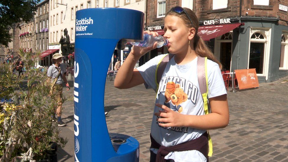 Young woman refills water