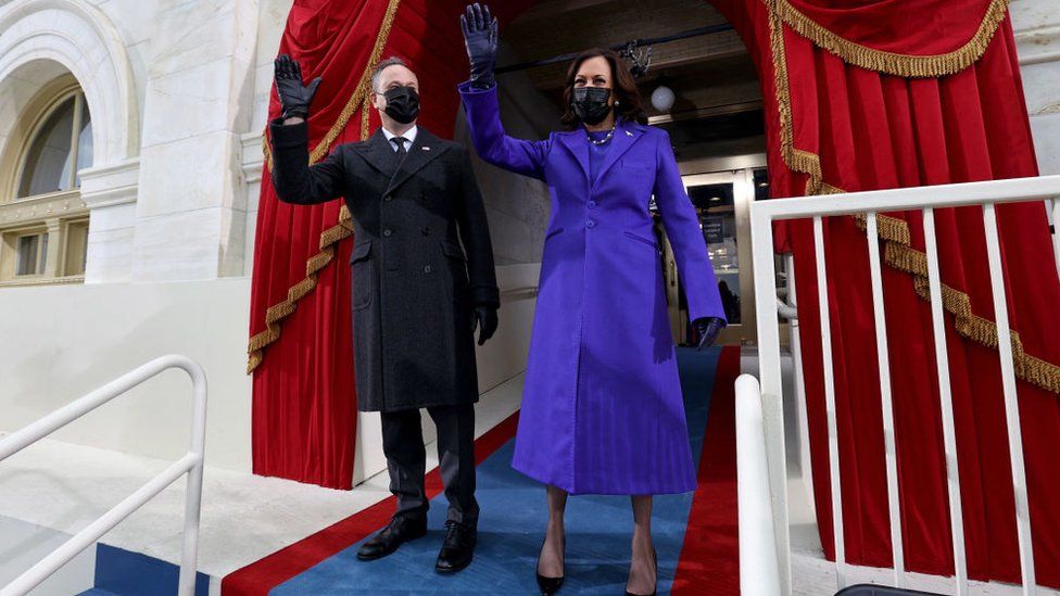 US Vice President Kamala Harris (R) and US Second Gentleman Doug Emhoff wave as they arrive for the inauguration