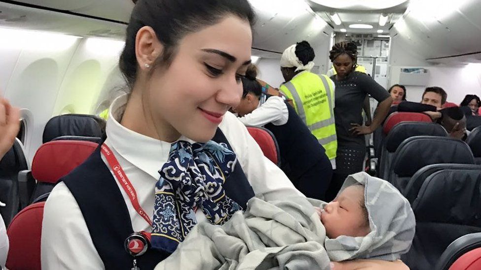 Air steward with baby Kadiju
