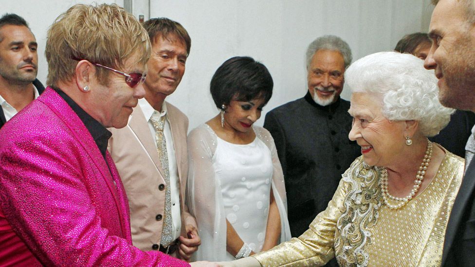 Сэр Элтон Джон встречается с королевой за кулисами концерта «Бриллиантовый юбилей» в 2012 году, с сэром Клиффом Ричардом, дамой Ширли Бэсси и сэром Томом Джонсом на заднем плане