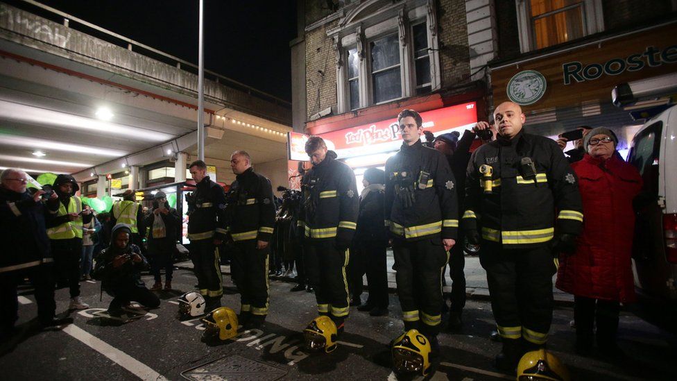 Firefighters stand to attention