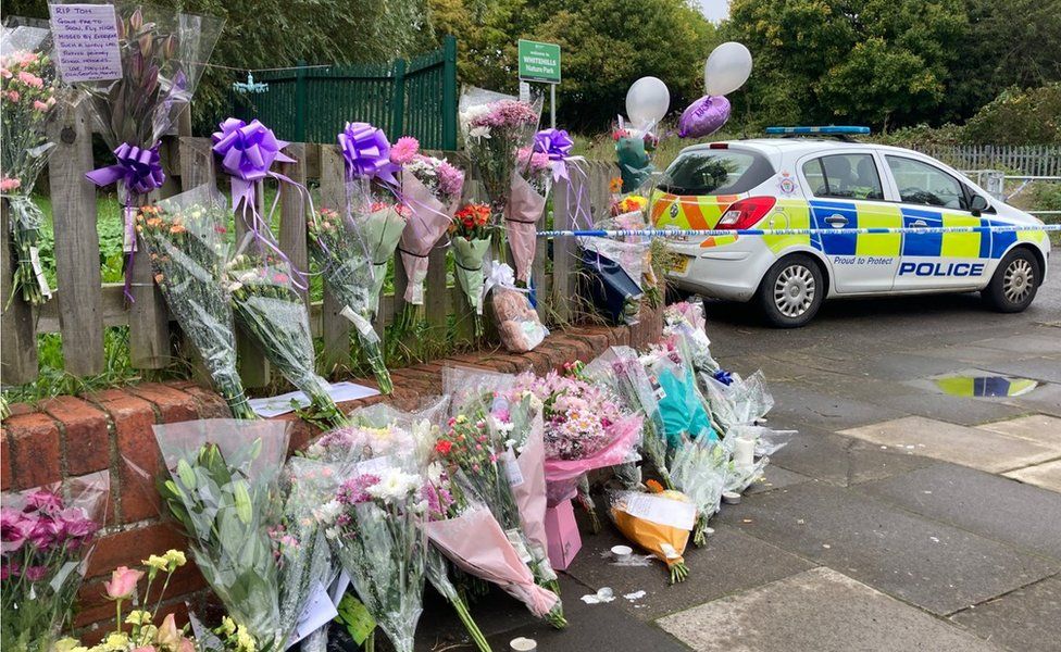 Floral tributes left near the scene where Tomasz was injured