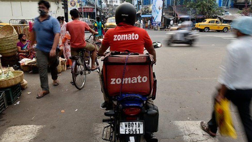 A Zomato delivery boy waits to cross a road in Kolkata, India, 18 November, 2020.