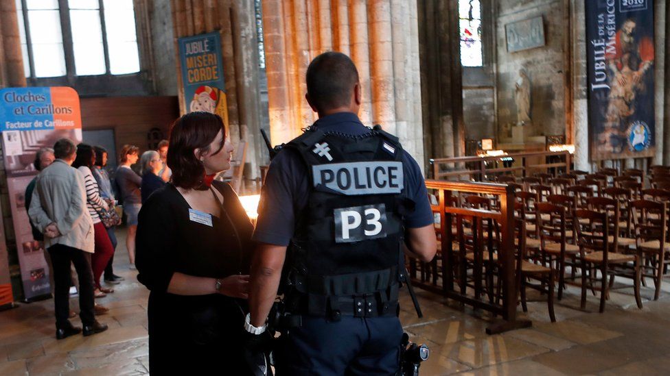 A police officer stands guard during a mass in tribute to priest Jacques Hamel who was killed by two attackers at the Saint Etienne church, in the Cathedral Notre Dame in Rouen, Normandy, France, Wednesday, July 27, 2016.