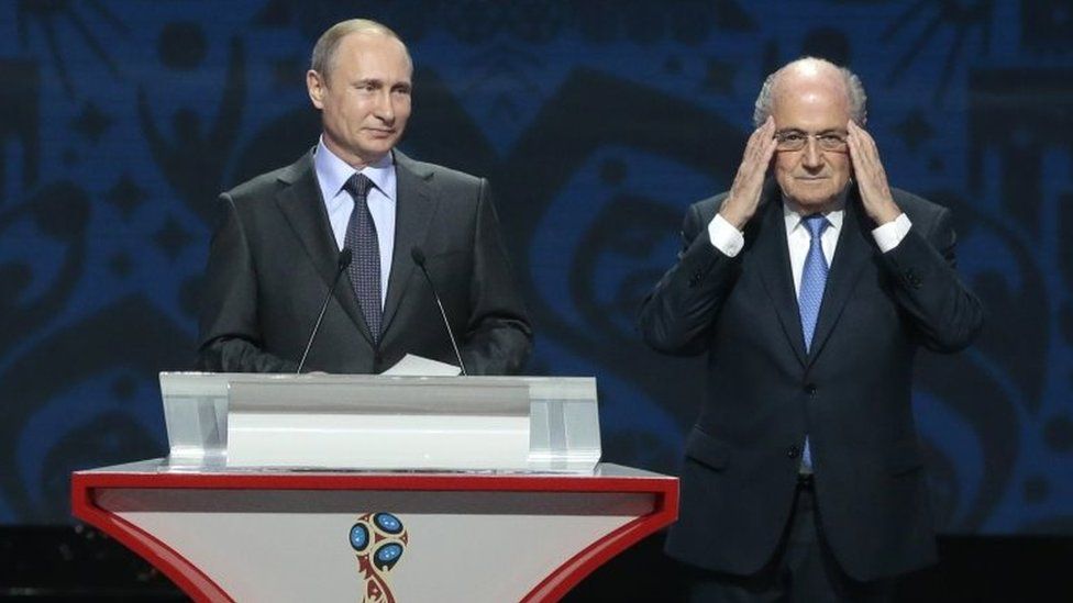 Sepp Blatter (right) adjusts his glasses during a speech by Russian President Vladimir Putin during the preliminary draw for the 2018 soccer World Cup in St Petersburg (25 July 2015)