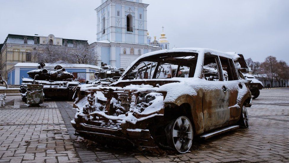 Monastery of Saint Michel of Golden Domes covered with snow and view of the memorial of war with destroyed Russian military vehicles are seen in Kyiv