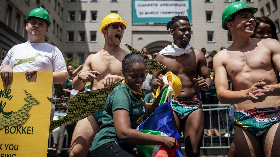Springbok supporters wear South African flag speedos to mimic Springbok scrumhalf Faf de Klerk attire on the winning night of the Rugby World Cup during a parade through the streets of Johannesburg CBD on an open top bus while showing the Web Ellis trophy on November 7, 2019 in Johannesburg, South Africa.