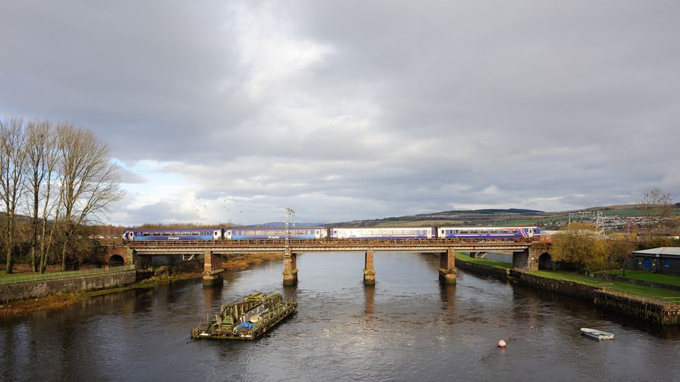 A train passes over the River Leven