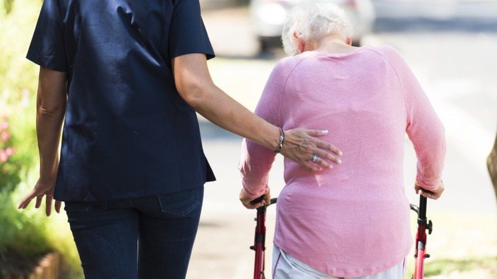 Caregiver helping an elderly woman