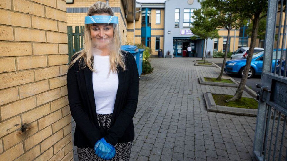 Ashleigh Clarke, teacher at St Clare's Primary School in Belfast, wearing a protective visor and gloves on Monday 24 August, as P7 pupils are allowed to return to school in Northern Ireland