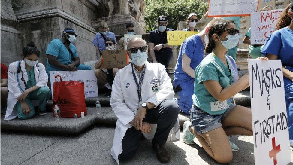 Healthcare workers kneel in silence during a protest at Columbus Circle, 12 days on after George Floyd"s death in police custody, in New York, USA, 06 June 2020