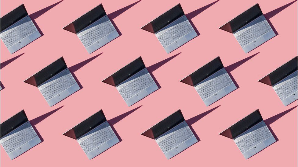 A selection of open laptops on a pink background is used to illustrate the concept of a network of compromised computers