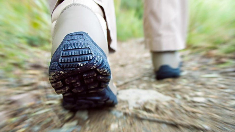 Boots walking through country terrain