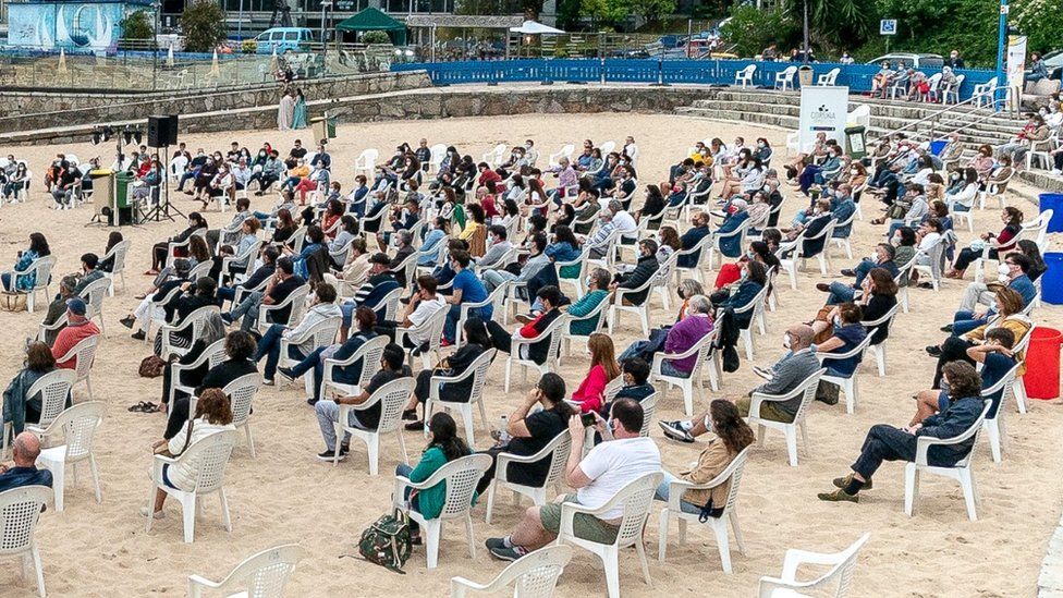 The audience maintains social distance during a performance on a beach in A Coruna, Spain, 4 July