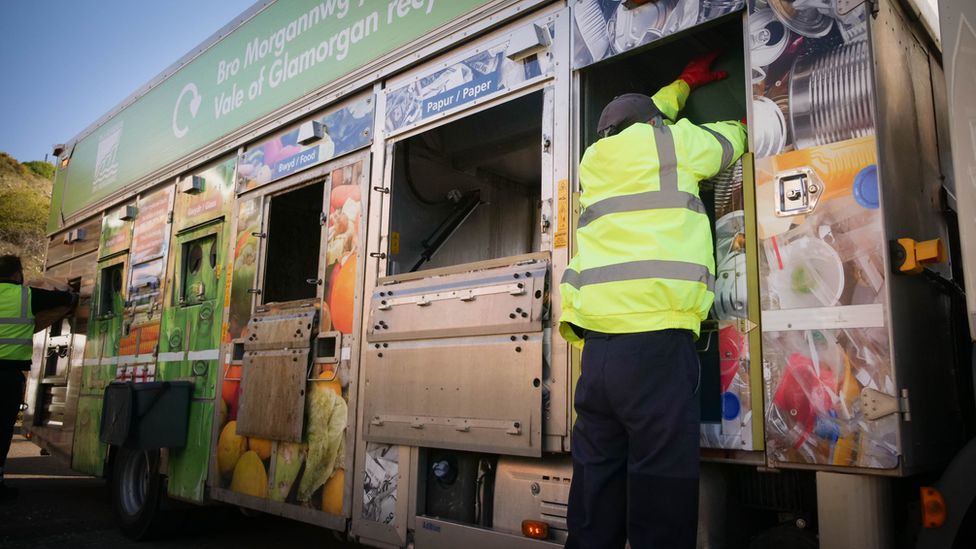 Council staff loading a recycling wagon