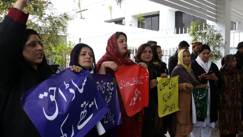 Supporters of jailed former prime minister Imran Khan hold placards as they protest before the start election of Speaker