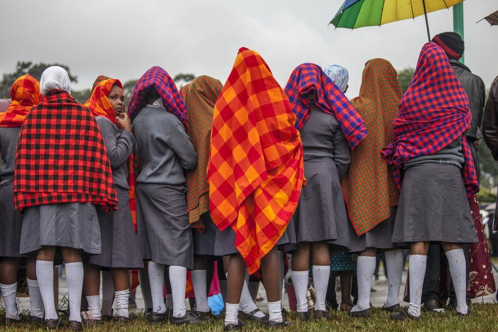 Young women gather under the rain at the University of Nairobi ahead of an open-air mass delivered by the Pope in Kenya - Thursday 26 November 2015