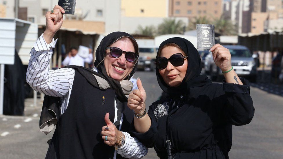 Kuwaiti women display their passports as they vote during parliamentary elections in Kuwait City on September 29, 2022