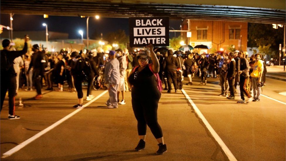A protester in Rochester, New York holds a sign saying "Black Lives Matter"