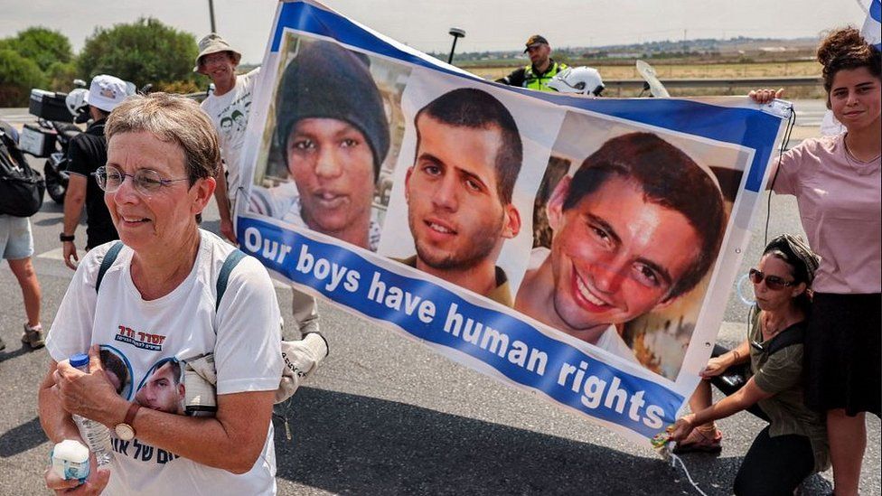 Rally demanding that Hamas release Avera Mengistu (L on banner) and remains of Israeli soldiers Oron Shaul (C) and Hadar Goldin (R), Karmia kibbutz, 5 Aug 22