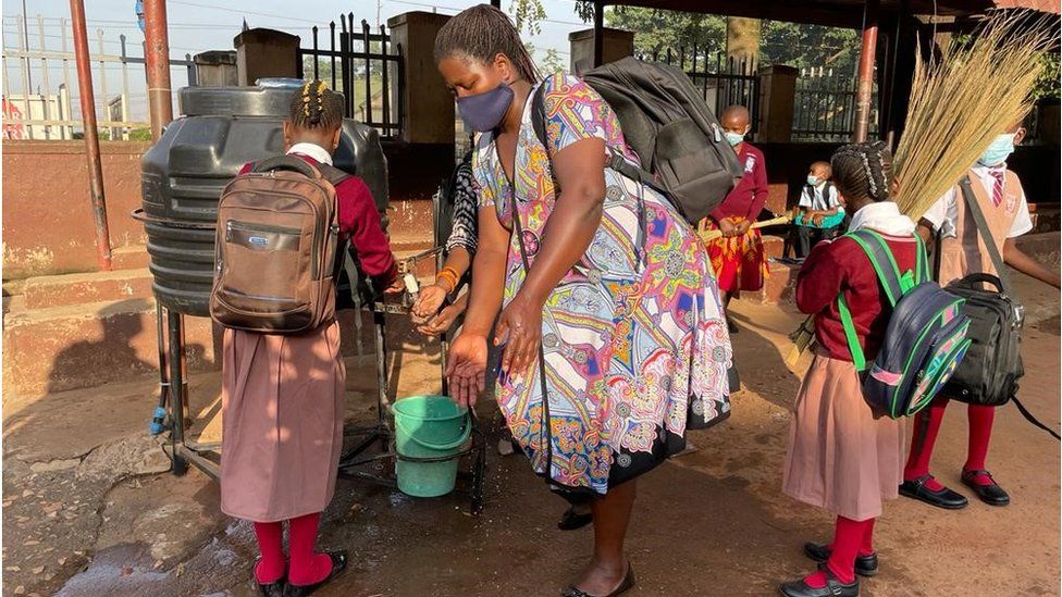 Ugandan students washing their hands outside