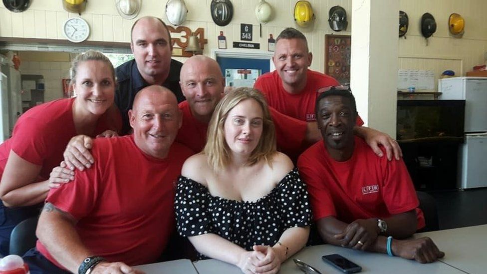Picture of Adele with firefighters
