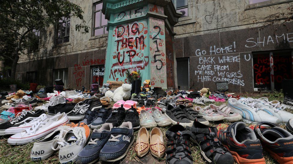 Children's shoes left at the base of a vigil, at the statue of Egerton Ryerson, considered the architect of the indigenous school system