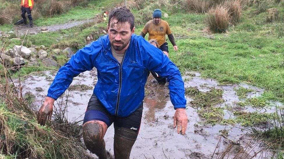 Runners traverse muddy fields