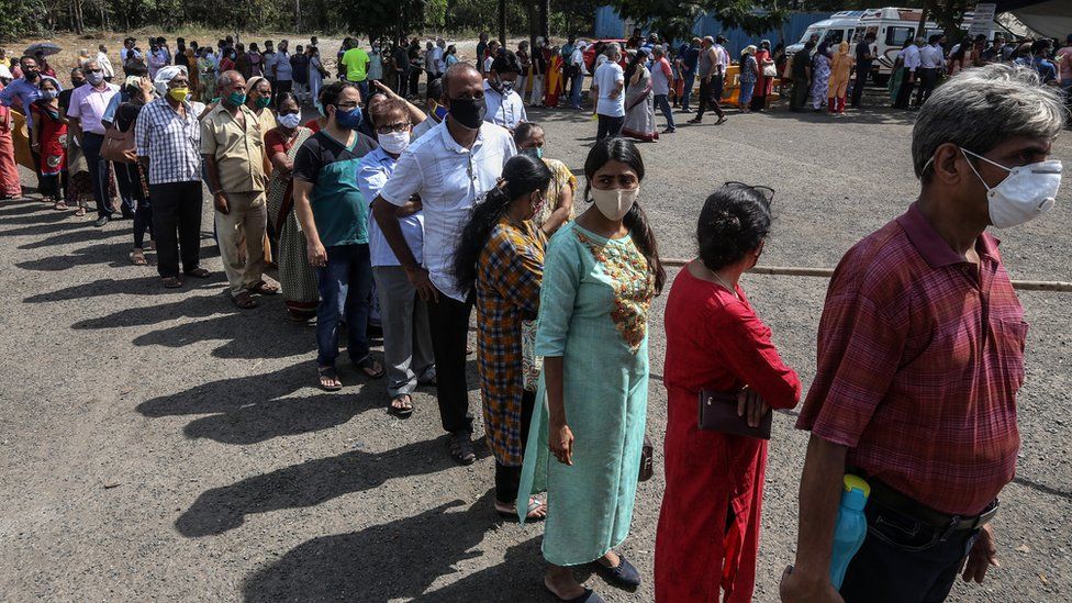 A queue of people wait to receive a coronavirus vaccine in Mumbai