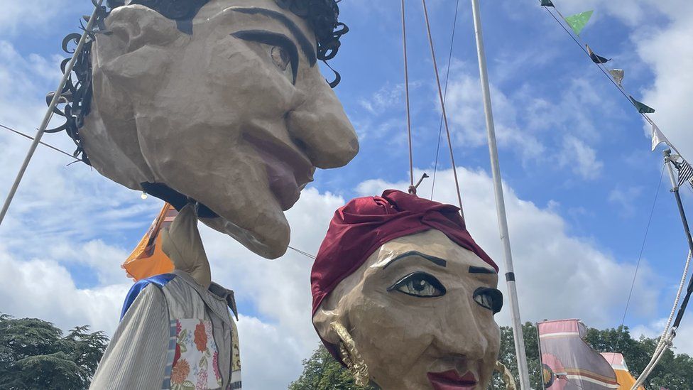 Two big statues of people at the festival