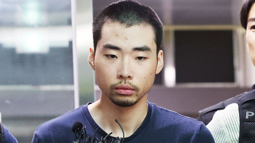 Чхве Вон Чжон, 22-летний мужчина, арестованный за нанесение ножевых ранений, выводят из полицейского участка в Соннаме, Южная Корея, 08.10.2023 г., когда его отправляют в прокуратуру по обвинению в убийстве и покушении на убийство. .