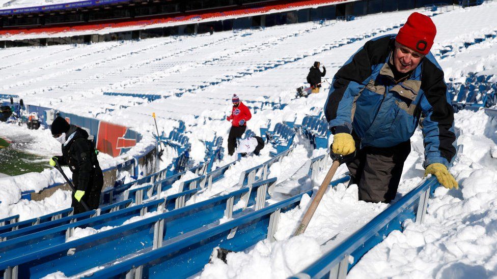 A worker shovels snow before the AFC Wild Card playoff game between the Buffalo Bills and Pittsburgh Steelers at Highmark Stadium on January 15, 2024 in Buffalo, New York.