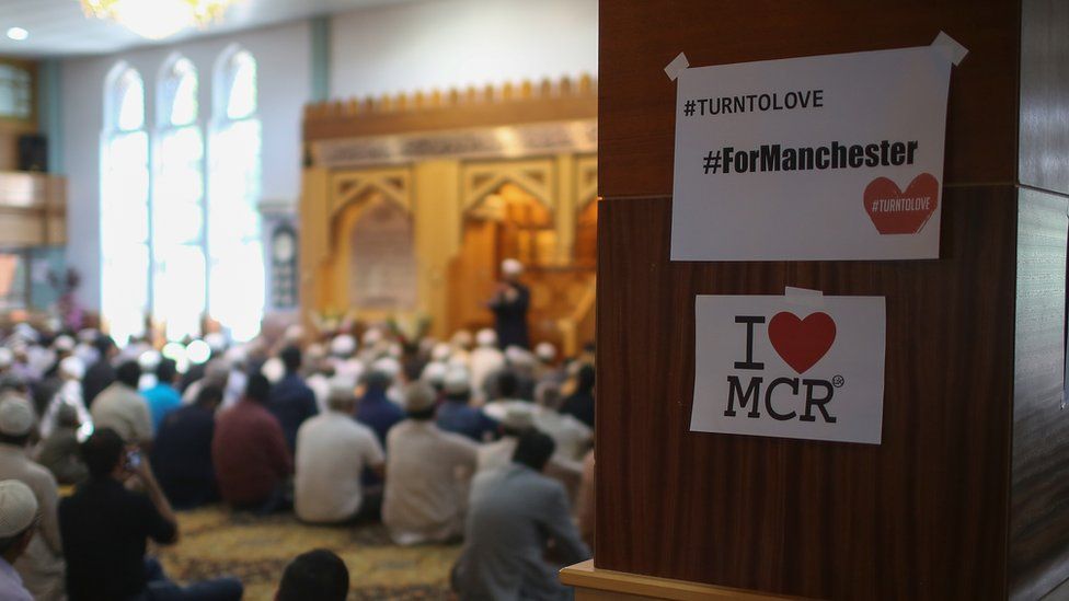 worshippers at Manchester mosque with i heart MCR sign